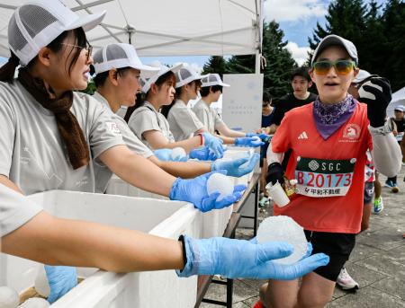 北海道マラソンで、雪玉を受け取るランナー＝３１日午前、札幌市