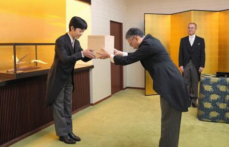 「冠を賜うの儀」で、天皇陛下の使者から成年用の冠を受け取られる秋篠宮家の長男悠仁さま=6日午前8時45分、東京・元赤坂の秋篠宮邸(宮内庁提供)