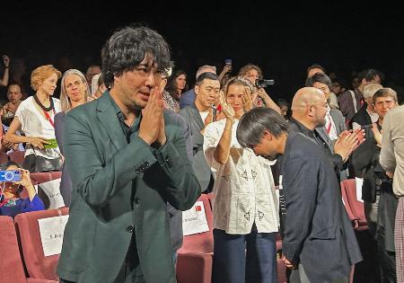 　ベネチア国際映画祭で「ＬＯＳＴ　ＬＡＮＤ／ロストランド」の公式上映後、観客の拍手に応える藤元明緒監督（手前）＝１日、イタリア・ベネチア