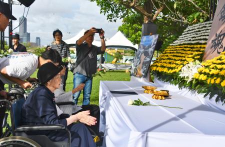 献花台の前で手を合わせる廖淑霞さん（手前）＝７日、台湾南部・高雄市（共同）