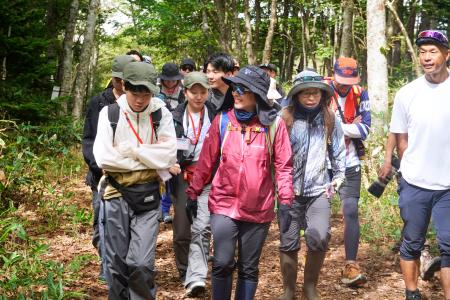地域の中高生の案内で森を散策する参加者ら＝７日午前、北海道斜里町（画像の一部を加工しています）