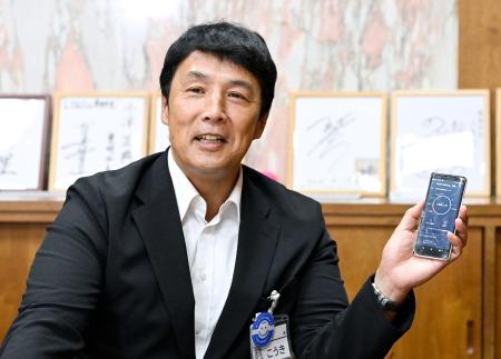 自身のスマートフォンを手に、インタビューに答える愛知県豊明市の小浮正典市長