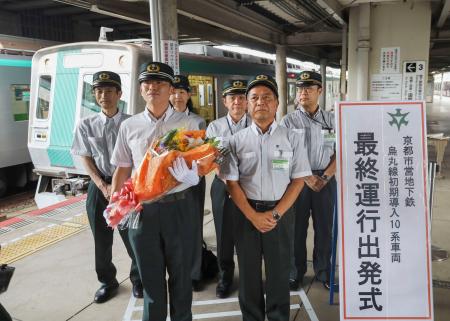 京都市営地下鉄烏丸線の竹田駅で行われた初期車両の引退セレモニー。手前左は花束を手にする長尾耕太郎さん＝８日午後