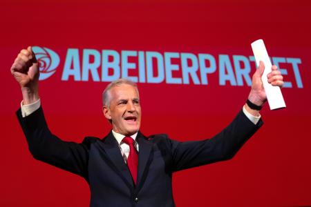 ８日、議会選の結果を受け両手を上げるノルウェーのストーレ首相＝オスロ（ゲッティ＝共同）