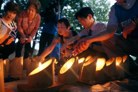 　東海豪雨から２５年となり、犠牲者を追悼する集会で並べられた竹灯籠＝１１日午前、名古屋市