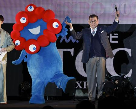 大阪・関西万博会場の視察に訪れ、ファッションイベントで公式キャラクター「ミャクミャク」と共に登場した石破首相＝４月、大阪市此花区