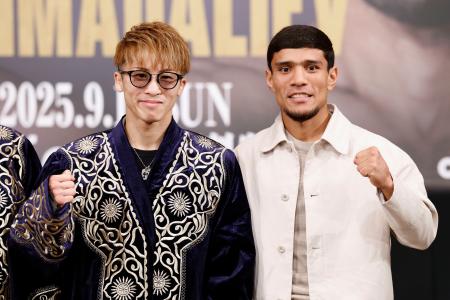 　ムロジョン・アフマダリエフ（右）から贈られた伝統衣装を着てポーズをとる井上尚弥＝１２日、名古屋市