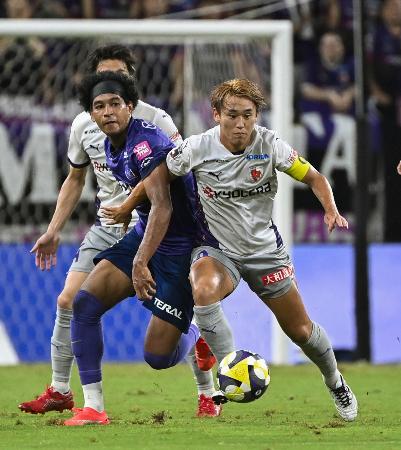 　広島―京都　前半、競り合う広島・ジャーメイン（左）と京都・福岡＝Ｅピース