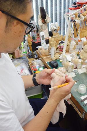 　江戸木目込み人形の「力士ペーパーウエイト」を制作する塚田真弘さん＝東京都墨田区