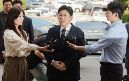 韓国警察に出頭し、取材に答える大手芸能事務所「ＨＹＢＥ（ハイブ）」の創業者、房時赫氏（中央）＝１５日、ソウル（聯合＝共同）