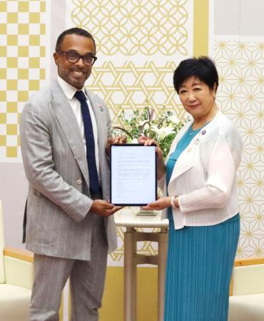 協定書を掲げる東京都の小池百合子知事（右）とグーグルのクリス・ターナー副社長＝１６日午後、東京都庁