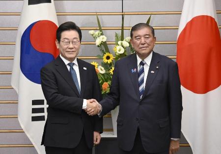 日韓首脳会談を前に握手する石破首相（右）と韓国の李在明大統領＝８月、首相官邸