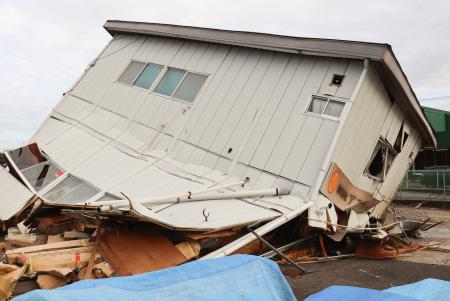 １階部分が倒壊した建物＝１９日午後、茨城県つくば市