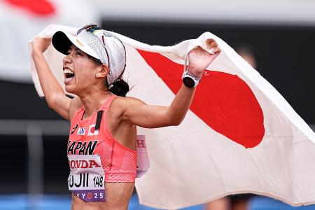 女子２０キロ競歩　銅メダルを獲得し、日の丸を掲げる藤井菜々子＝国立競技場