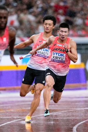 男子400メートルリレー決勝 2走の柳田大輝(左)からバトンを受け、力走する3走の桐生祥秀=国立競技場