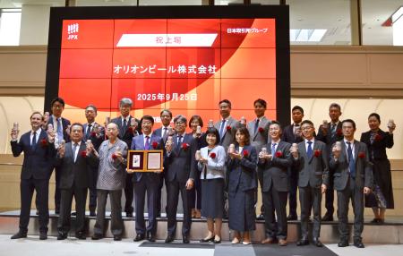 東証プライムに上場し、記念撮影をするオリオンビールの関係者ら＝２５日午前、東京都中央区
