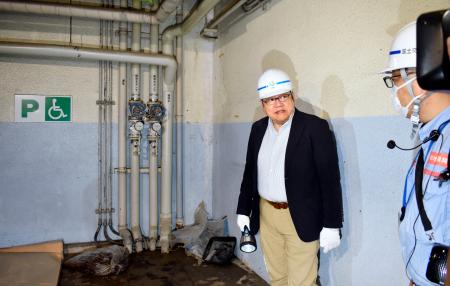 冠水した地下駐車場を視察し、排水装置の状態を確認する三重大大学院の川口淳教授（左）＝２６日午前、三重県四日市市