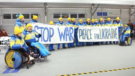 北京冬季パラリンピックの開会式を前に、横断幕を掲げて反戦と平和を訴えるウクライナ選手団＝２０２２年３月、北京（ウクライナ・パラリンピック委員会提供、共同）