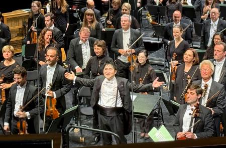 ２７日、ブザンソン国際若手指揮者コンクールの決勝で、大きな拍手を受ける米田覚士さん（下中央）＝フランス東部ブザンソン（共同）