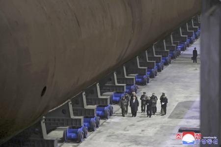 潜水艦の船底部分を視察する北朝鮮の金正恩朝鮮労働党総書記（手前左から２人目）（朝鮮中央通信＝共同）