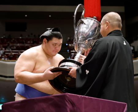 大相撲秋場所で、横綱として初となる優勝を果たし、日本相撲協会の八角理事長（右）から賜杯を受け取る大の里＝２８日、東京・両国国技館