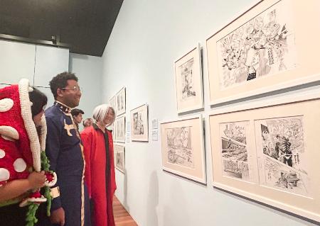 ２７日、米サンフランシスコのデ・ヤング美術館で、展示された漫画の原画を見る来場者（共同）