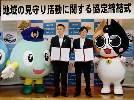 地域の見守り活動を実施する協定を岩手県警と結び、写真に納まる岩手日報会の三浦義之会長(右)ら=29日午後、盛岡市