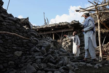 アフガニスタン東部ナンガルハル州で、損壊した家を見つめる住民=9月6日(ロイター=共同)