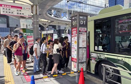 観光バスに乗り込む旅行者ら＝７月、京都市