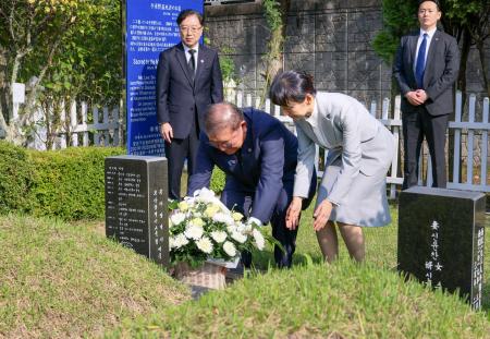 ＪＲ新大久保駅転落事故で亡くなった韓国人留学生の李秀賢さんの墓地を参拝し、献花する石破首相。右は妻の佳子さん＝３０日、韓国・釜山（内閣広報室提供・共同）