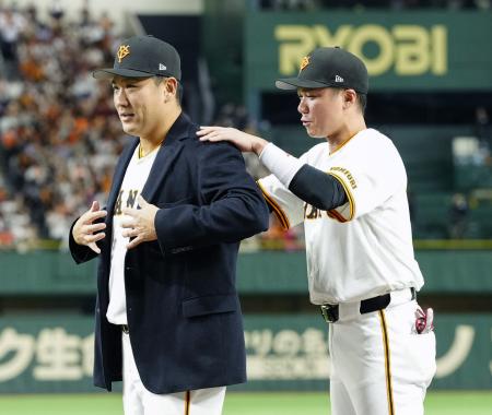 日米通算２００勝達成を記念するセレモニーで、坂本勇人内野手（右）から受け取った名球会ブレザーを着る巨人・田中将大投手＝１日、東京ドーム