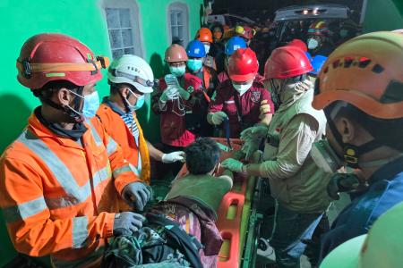 １日、インドネシア・シドアルジョで、倒壊したイスラム寄宿学校の建物で救助活動をする救急隊員（国家捜索救助庁提供・ゲッティ＝共同）