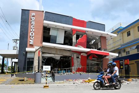 2日、フィリピン中部セブ島ボゴで、地震で損壊した店舗(共同)
