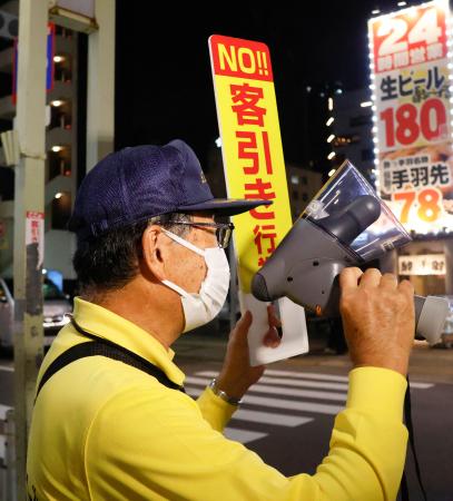 名古屋駅周辺で、客引きに対し注意喚起する指導員＝３日夕