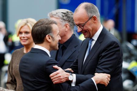 ３日、ドイツ西部ザールブリュッケンでフランスのマクロン大統領（左）とあいさつするメルツ首相（ロイター＝共同）