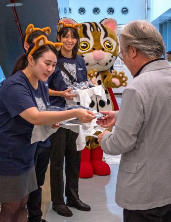 台北の松山空港で搭乗客に記念品を配る全日本空輸のスタッフら＝５日（共同）