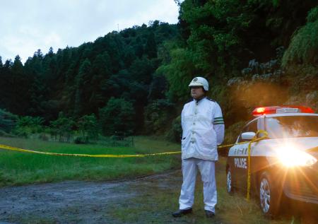 土砂崩れがあった現場近くで規制線を張り、警戒する警察官＝５日午後５時３４分、石川県小松市