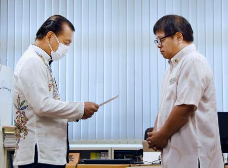 　南城市議会議長に解散通知書を手渡す古謝景春市長（左）＝６日午前、沖縄県南城市