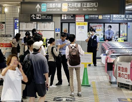東急田園都市線溝の口駅で、駅員から説明を受ける人たち=6日、川崎市高津区