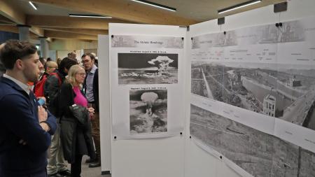 ６日、英北部スコットランドのスターリング大で開かれた原爆展で、原爆被害を伝える写真を見る人々（共同）