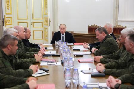 ７日、ロシア・サンクトペテルブルクで、国防省幹部らと会合を開いたプーチン大統領（中央奥）（ロシア大統領府提供・タス＝共同）