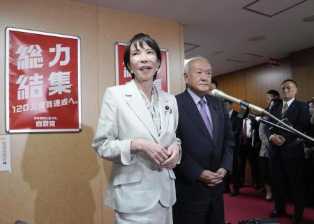 自民党本部で記者団の取材に応じる高市総裁。右は鈴木幹事長＝７日、東京・永田町