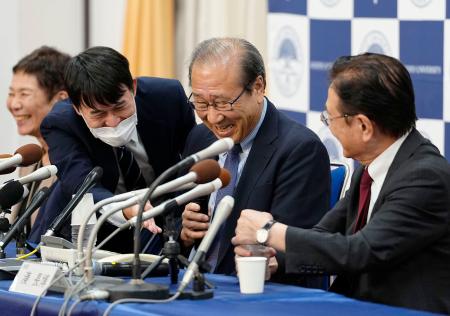 阿部文科相からの電話を誤って切ってしまい、戸惑う京都大の北川進氏（右から２人目）＝８日午後８時２８分、京都市左京区