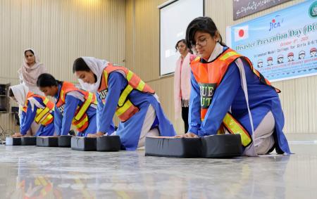 ８日、パキスタンの首都イスラマバードでＪＩＣＡなどが主催した防災訓練で、心臓マッサージを練習する女子生徒ら（共同）