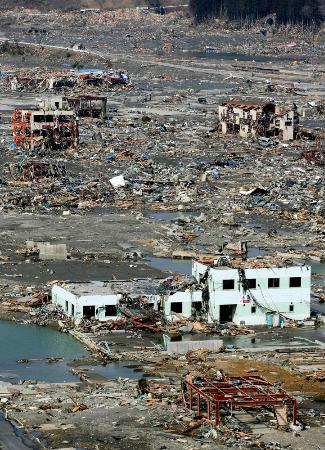 　津波で壊滅的被害を受けた宮城県南三陸町。わずかに残された建物をがれきが覆っている＝２０１１年３月１３日