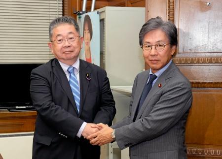 会談前に握手する立憲民主党の安住幹事長（右）と共産党の小池書記局長＝９日午後、国会