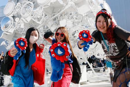 ミャクミャクグッズを手に万博を楽しむ女性グループ=9日、大阪市此花区の夢洲
