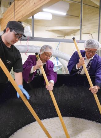 日本酒「絆舞」の仕込み作業に加わる信用金庫の役員(右2人)ら=11日午後、福島県会津坂下町