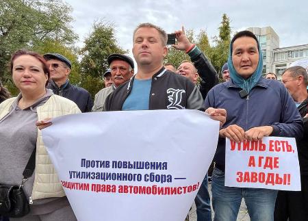 11日、ロシア極東ウラジオストクで開かれた廃物利用税引き上げに反対する集会で、メッセージを掲げる参加者(共同)