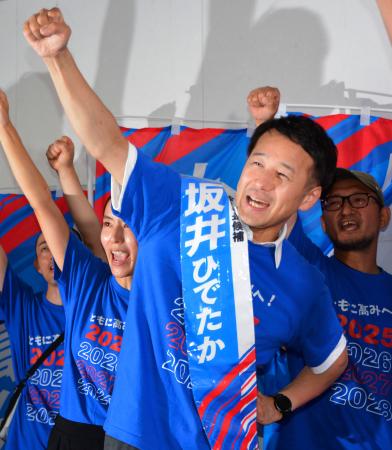 佐賀市長選で無投票での再選が決まり、拳を突き上げる坂井英隆氏＝１２日午後、佐賀市